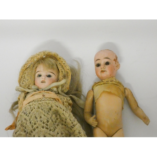 338 - Two miniature bisque head dolls - one has a small crack