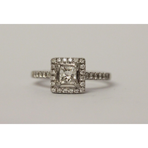 522 - A platinum and diamond engagement ring, central princess cut diamond surrounded by further diamonds ... 