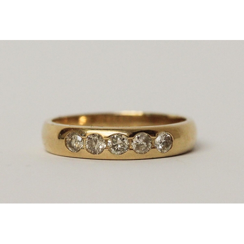 541 - 18ct yellow gold five stone diamond wedding band with brilliant cut diamonds in a rub over setting, ... 