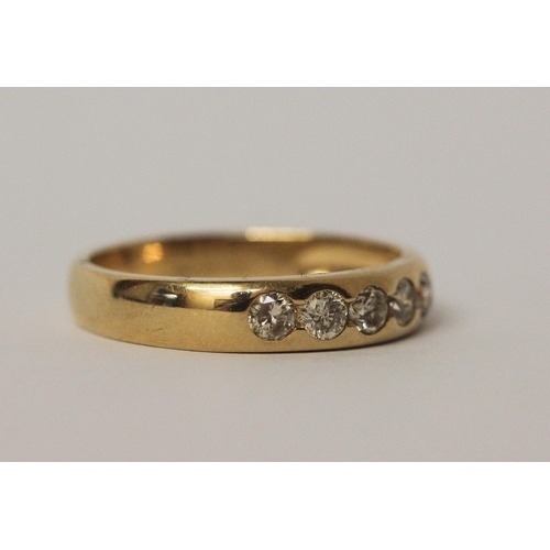 541 - 18ct yellow gold five stone diamond wedding band with brilliant cut diamonds in a rub over setting, ... 