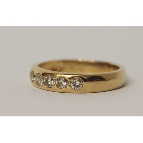 541 - 18ct yellow gold five stone diamond wedding band with brilliant cut diamonds in a rub over setting, ... 