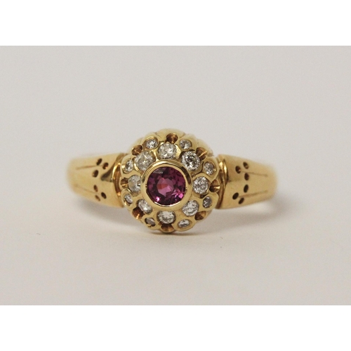 542 - A ruby and diamond circular cluster ring set in 18ct yellow gold, ring size R, 5.7gms