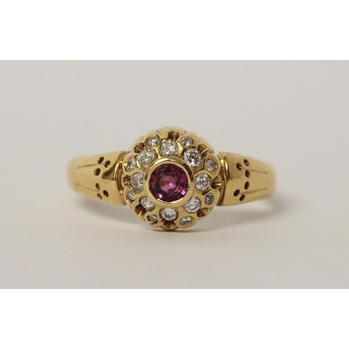 542 - A ruby and diamond circular cluster ring set in 18ct yellow gold, ring size R, 5.7gms