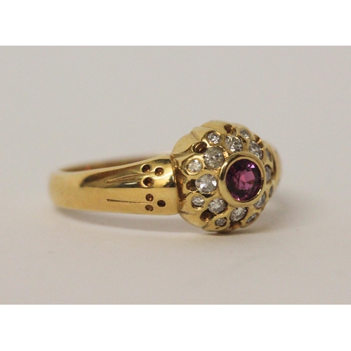 542 - A ruby and diamond circular cluster ring set in 18ct yellow gold, ring size R, 5.7gms