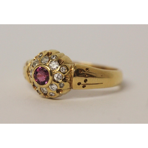 542 - A ruby and diamond circular cluster ring set in 18ct yellow gold, ring size R, 5.7gms