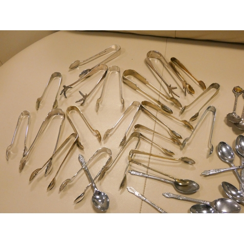 571 - A collection of assorted silver plate sugar nips, small quantity of commemorative spoons, other plat... 