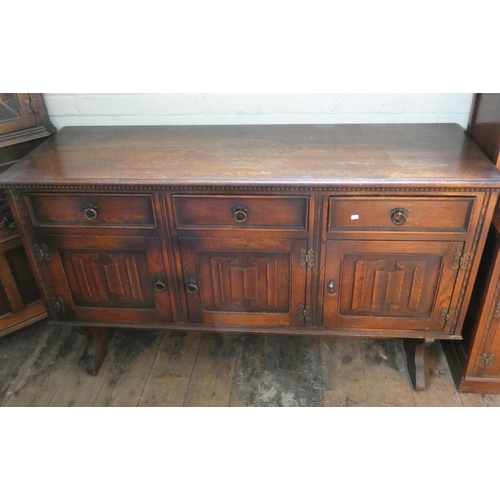 57 - A reproduction oak sideboard fitted three drawers and linen fold panel cupboards, 5' wide