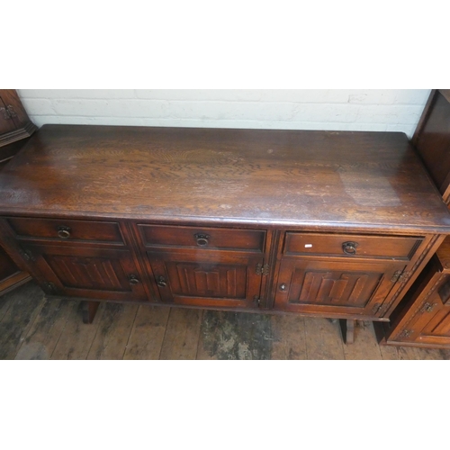 57 - A reproduction oak sideboard fitted three drawers and linen fold panel cupboards, 5' wide