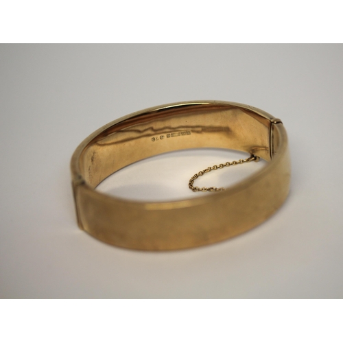 501 - 9ct yellow gold ladies hinged bangle, front panel with engraved scrolled work, snap clasp and safety... 