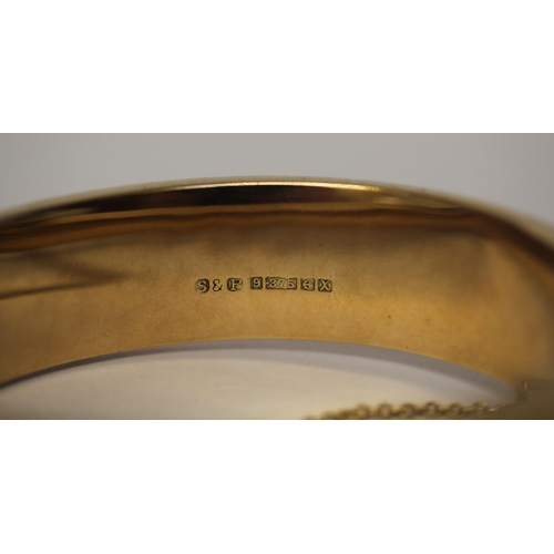 501 - 9ct yellow gold ladies hinged bangle, front panel with engraved scrolled work, snap clasp and safety... 