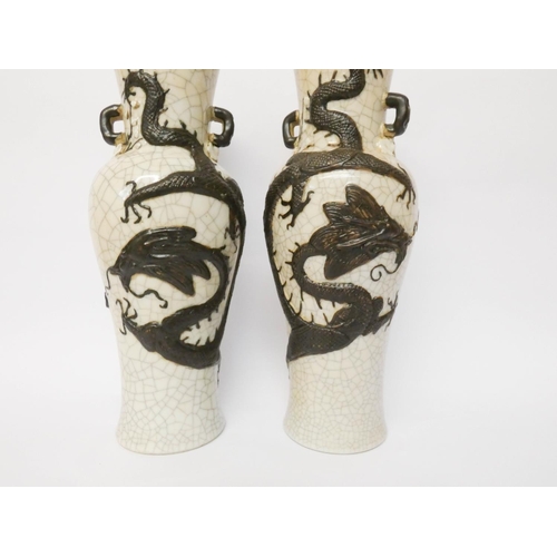 230 - A pair of Japanese crackle ware twin handled vases decorated in relief with a coiled dragon, seal ma... 