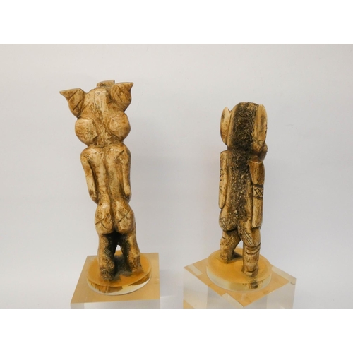 245 - A pair of carved bone tribal figures, later mounted on flexi-glass bases, height overall 35cms