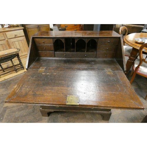 299 - An 18th century oak bureau with fitted interior and four long drawers under, with brass fall handles... 