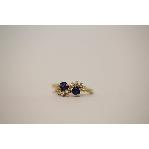 547 - Sapphire two stone ring, claw set with two circular sapphires of good colour, nine brilliant cut dia... 