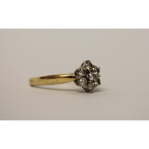 567 - A diamond daisy seven stone cluster ring on hallmarked 18ct gold shank, ring size L, 3.7gms