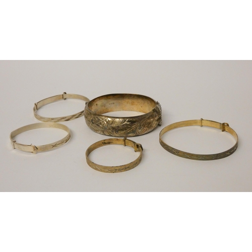 524 - A wide silver hinged bangle and four further christening bangles