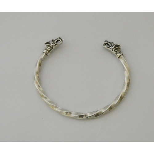 627 - A silver torque twist bangle with wolf head finials.