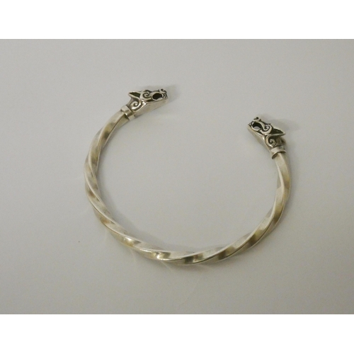 627 - A silver torque twist bangle with wolf head finials.