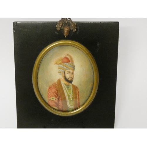 156 - A 19th century Indian portrait miniature - the oval half-length portrait of a young Mughal Prince.  ... 