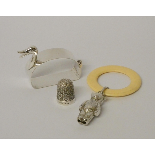 507 - A child's teething ring with silver teddy bear rattle, a silver novelty napkin ring modelled as a du... 