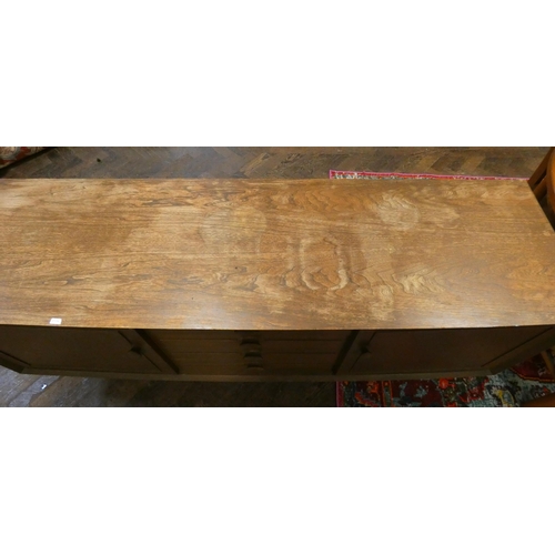 15 - A 1970's long low teak sideboard fitted four centre drawers and cupboards, 5'6 wide, need polish - a... 