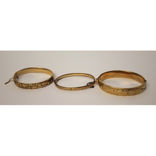 426 - Three vintage rolled gold hinged bangles.