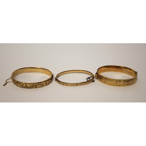 426 - Three vintage rolled gold hinged bangles.