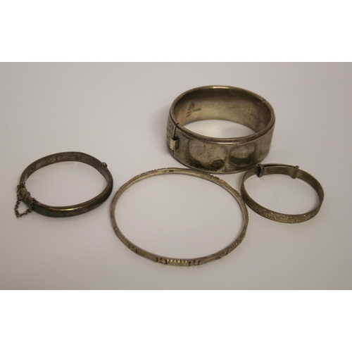 429 - Four silver bangles of various forms. 80 grams.