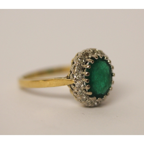 442 - An emerald and diamond cluster ring. On 18ct gold band. Ring size L 1/2.