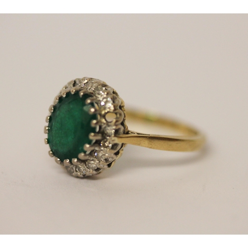 442 - An emerald and diamond cluster ring. On 18ct gold band. Ring size L 1/2.