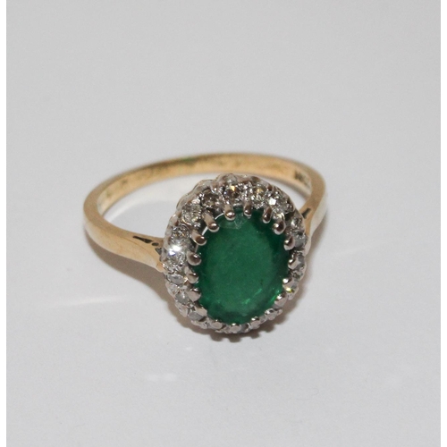 442 - An emerald and diamond cluster ring. On 18ct gold band. Ring size L 1/2.