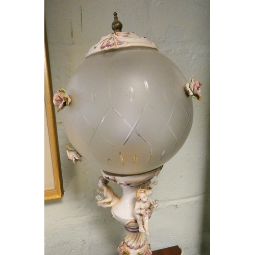 76 - A decorative cherub mounted table lamp with floral decorated globe shade, 26