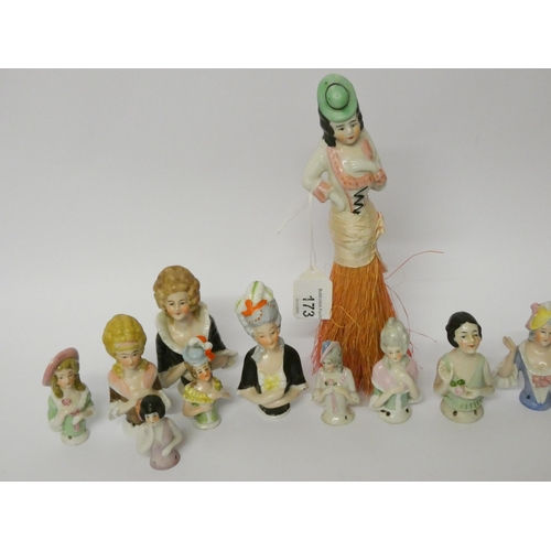 173 - Thirteen small porcelain pin cushions dolls and a similar brush