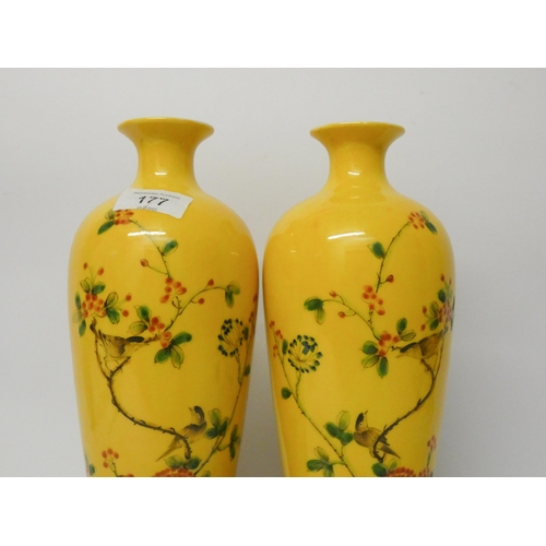 177 - A pair of Chinese yellow bird and floral decorated vases with wooden stands, 11 1/4