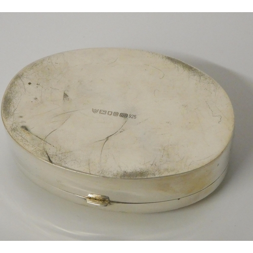 524 - A hallmarked silver oval snuff box, the hinged lid hand painted with hunting scene. 8cms across appr... 