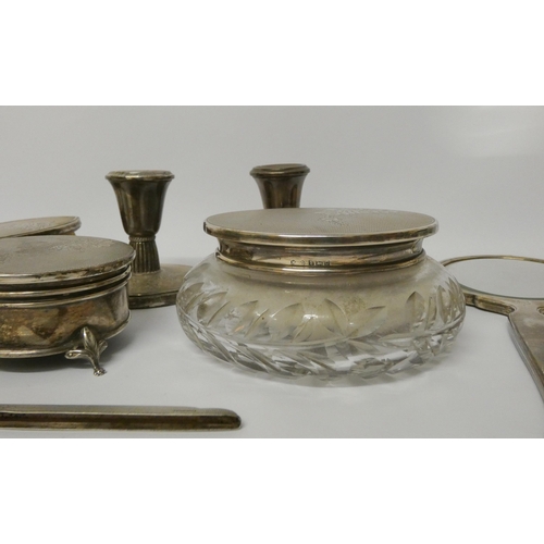 533 - A silver dressing table set - comprising pair of circular based candlesticks, a cut glass powder bow... 