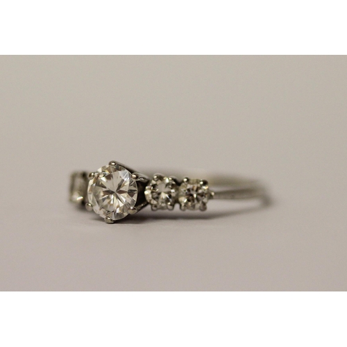 489 - A diamond ring, claw set circular brilliant cut diamond weighing 0.6cts, with further diamonds to th... 