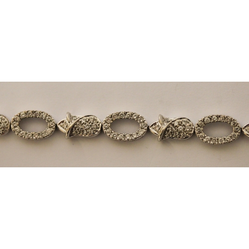 493 - Modern 18ct gold diamond bracelet, comprising alternate open and flower design links all set in 18ct... 