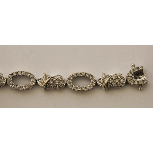 493 - Modern 18ct gold diamond bracelet, comprising alternate open and flower design links all set in 18ct... 