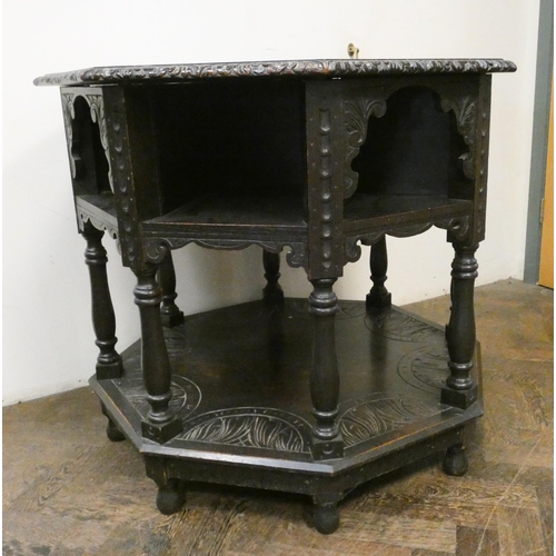 137 - An octagonal carved dark oak centre table with under tiers, 34