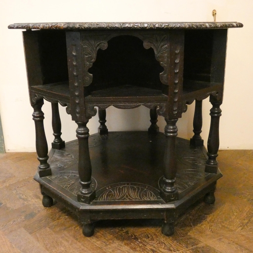 137 - An octagonal carved dark oak centre table with under tiers, 34