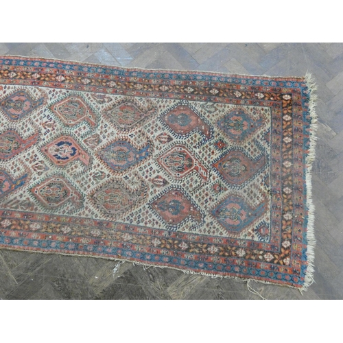 178 - A Persian wool pile carpet runner decorated with medallions and borders - a very worn patch to one e... 