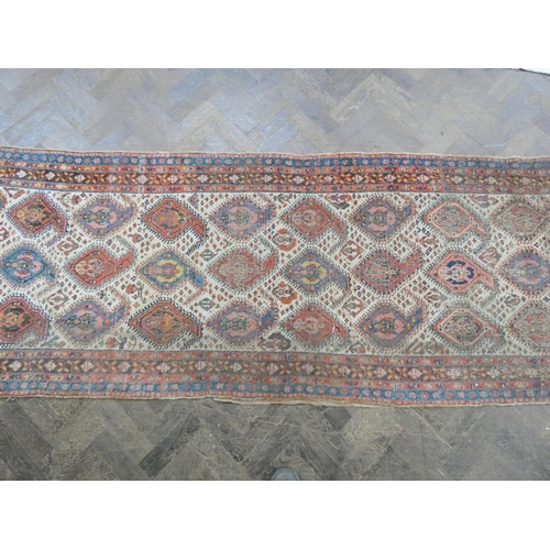 178 - A Persian wool pile carpet runner decorated with medallions and borders - a very worn patch to one e... 