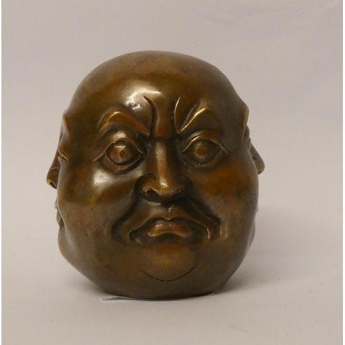 226 - A four sided Buddha head bronze paperweight