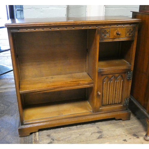 117 - A reproduction low oak open bookcase fitted cupboard and drawer with linen fold panels, 37