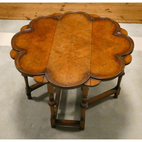 150 - A 1920's walnut occasional coffee table with drop leaves with a floral shaped top standing on turned... 