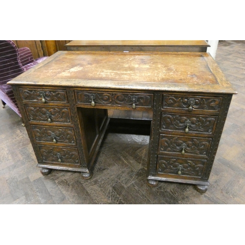 165 - A Victorian carved oak kneehole desk fitted nine drawers with inset brown leather top, 4' X 2'3