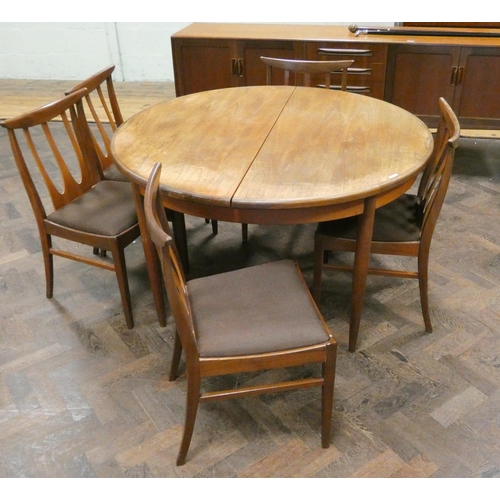 180 - A GPlan circular teak extending dining table with fold away centre leaf together with five similar c... 