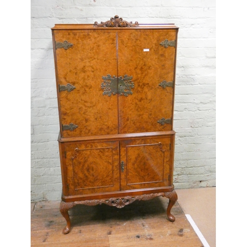 195 - A figured walnut four door cocktail cabinet with brass furniture standing on cabriole legs, 35