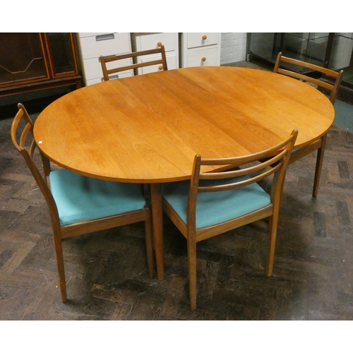 32 - A 1980's circular GPlan extending dining table with fold away centre leaf together with four matchin... 